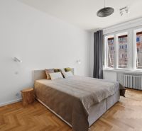 A bedroom with wood-patterned flooring and a large window in a 4-room apartment.