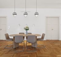 Dining area with an oval table and chairs, floor with wood decor.