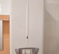 Gas boiler in a family house with a white interior and tiles.