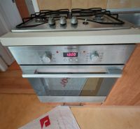 A kitchen with a gas stove and oven, wooden decor flooring in a family house.