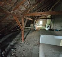 The attic in the family house with scattered building materials on the floor.