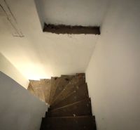 A staircase leading to the basement in a family house with white walls.