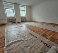A room with a wooden decor floor in a family house, ready for renovation.