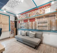 Interior of a family house with a sofa, acoustic panels, and a wooden decor floor.