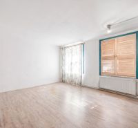 A room in a family house with white walls and a wooden decor floor.