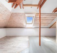 An attic in a family house with a window and a wooden decor floor.