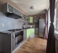 A kitchen in a 2-room apartment with a wood-patterned floor and modern appliances.