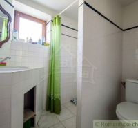 A bathroom in a family house with white tiles and a green curtain.