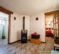 Interior of a family house with a fireplace, tiled floor, and wooden decorative elements.