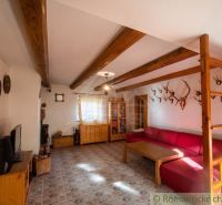Interior of a family house with trophies, wooden decor flooring, red sofa, light walls.