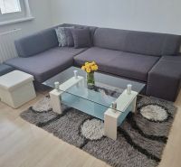 Gray sofa with a coffee table and a carpet, 3-room apartment.