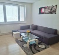 Living room in a 3-room apartment with a sofa, glass table, and wood-patterned flooring.