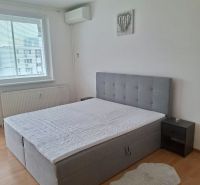 Bedroom in a 3-room apartment with a bed extension and flooring with a wood decor.