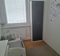 Children's room with a bed and a wardrobe in a 3-room apartment with a wooden decor floor.