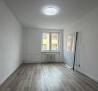 Interior of a 3-room apartment with a wooden decor floor and white walls.