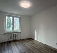 An empty room with a wooden decor floor in a 3-room apartment.