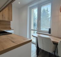 A kitchen in a 3-room apartment with a kitchen unit and a floor with a wood decor.