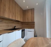 A kitchen in a 3-room apartment with a wooden decor floor and a built-in unit.