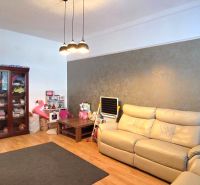 Interior of a 2-room apartment with a wooden decor floor, sofa, and cabinet.