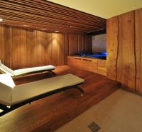 Relaxation area with loungers, wooden elements, and flooring with a wooden decor in a recreational apartment.