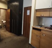 Kitchen corner with cabinets and a sink in a holiday apartment, next to the entrance to the bathroom.
