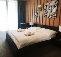 Bedroom with a double bed and decorative paintings in a holiday apartment.