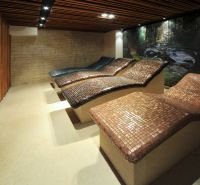 Loungers in a recreational apartment with stone decor and a wooden wall.