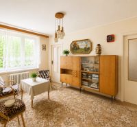 Living room in a 3-room apartment with retro furniture and a large window.