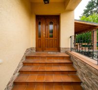 Entrance stairs to a family house on Kpt. Jaroša in Trenčín with wooden doors and railing.