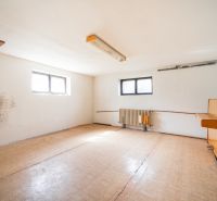 A spacious room in a family house with a wooden decor floor and windows.