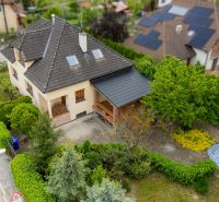 A family house on Kpt. Jaroša in Trenčín surrounded by greenery and trees, with a sloped roof.