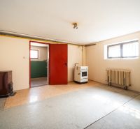 A simple room in a family house with a stove and a cooker, floor with a wooden decor.
