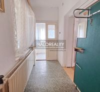 Interior of a family house with a hallway, radiator, and light curtains on the windows.