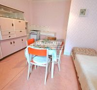A kitchen in a family house with retro furniture and pink walls.