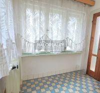 A small hallway in a family house with a tiled floor and curtains on the window.