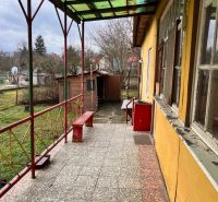 Terasa s lavičkami a dlažbou pri rodinnom dome v Komjaticiach, výhľad do záhrady.