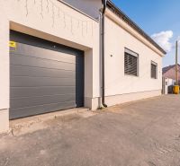 A garage at a family house on Orviský kút in Piešťany with a concrete walkway.