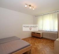 A bedroom in a studio apartment with a bed, furniture, and a wooden decor floor.