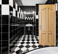 A bathroom in a 2-room apartment with black and white tiles and wooden doors.
