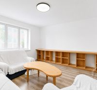 Living room in a 2-room apartment with light sofas and a wooden decor floor.