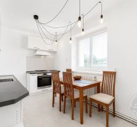 A kitchen in a 2-room apartment with a dining table and modern lighting.
