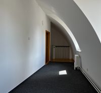 The interior of an office with carpeted flooring and an arched ceiling.