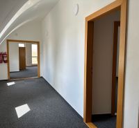 Offices with arched ceilings, white walls, and dark carpet in the interior.