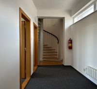Offices with carpet, staircase, and fire extinguisher.