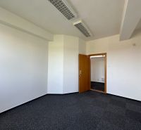 Offices with white walls and dark carpet, doors with wood decor.