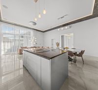 A spacious kitchen with an island and pendant lights in a family house.