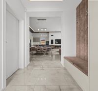 Interior of a family house with an open kitchen, dining area, and comfortable seating in the hallway.