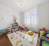 Children's room with toys, a colorful mat, and wall decorations in a family house.