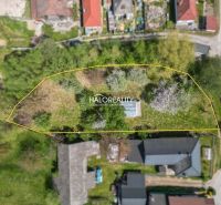 Aerial view of gardens in Považská Bystrica, surrounded by residential buildings and greenery.