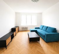 Living room with a sofa, furniture, and flooring with a wood decor in a 2-room apartment.